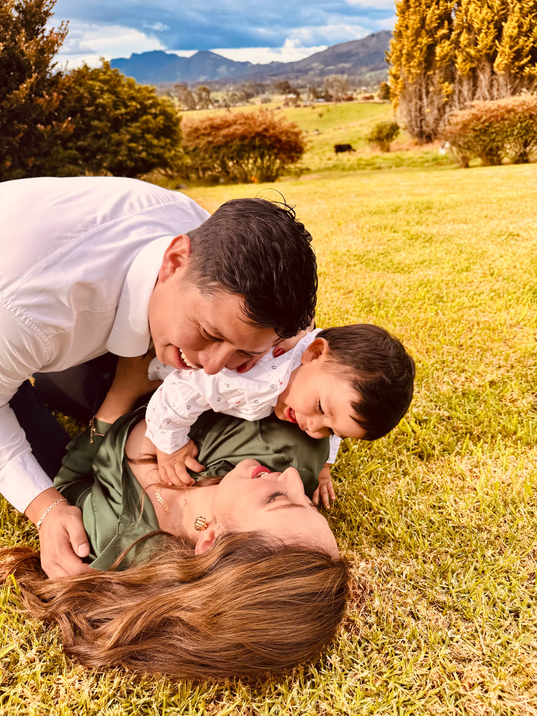 La familia riendo sobre el pasto